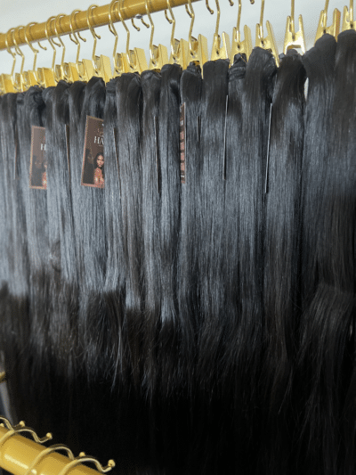 Straight Indian hair bundles in varying lengths displayed on a hair rack, showcasing the smooth, sleek texture and natural shine.