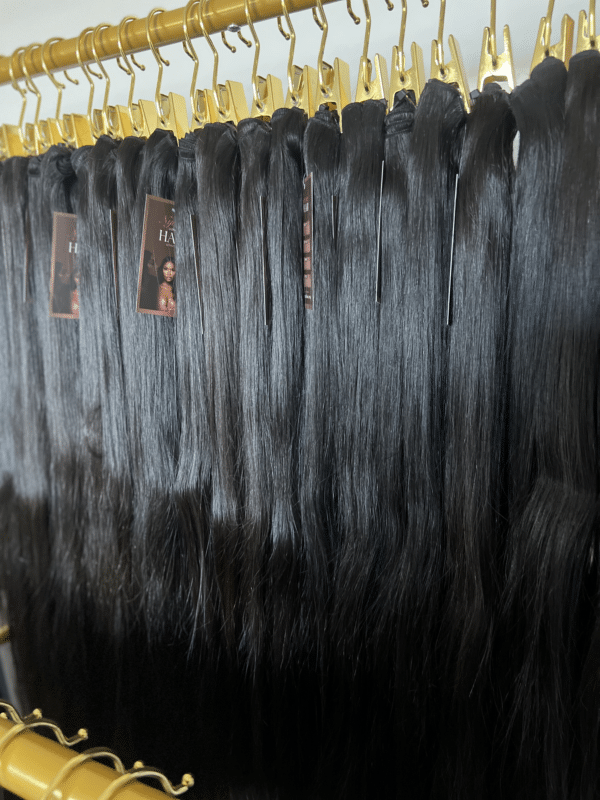 Straight Indian hair bundles in varying lengths displayed on a hair rack, showcasing the smooth, sleek texture and natural shine.