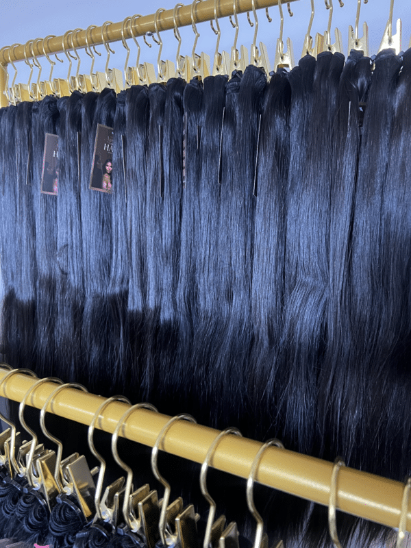 Straight Indian hair bundles in varying lengths displayed on a hair rack, showcasing the smooth, sleek texture and natural shine.