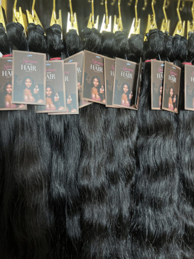 Wavy Indian hair bundles in different lengths displayed on a hair rack, highlighting the soft waves and natural movement of the hair.