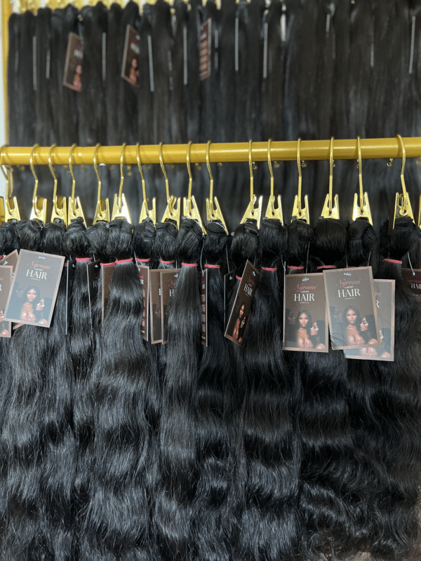 Wavy & Straight Indian hair bundles in different lengths displayed on a hair rack, highlighting the soft waves and natural movement of the hair.