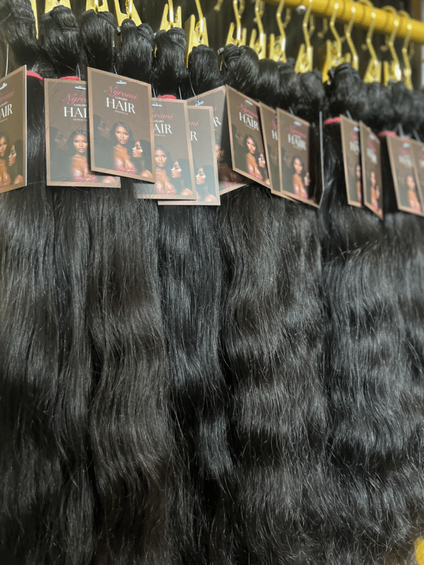 Wavy Indian hair bundles in different lengths displayed on a hair rack, highlighting the soft waves and natural movement of the hair.