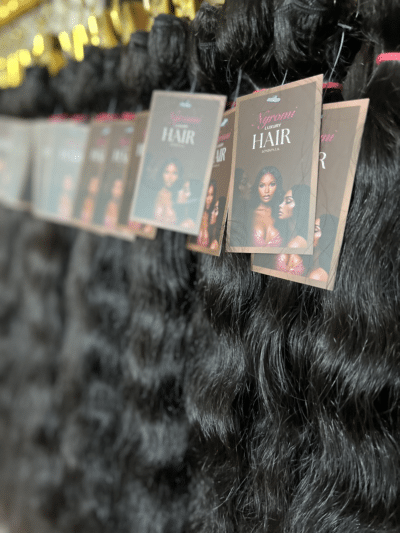 Curly Indian hair bundles in various lengths displayed on a hair rack, highlighting the tight curls and natural volume of the hair